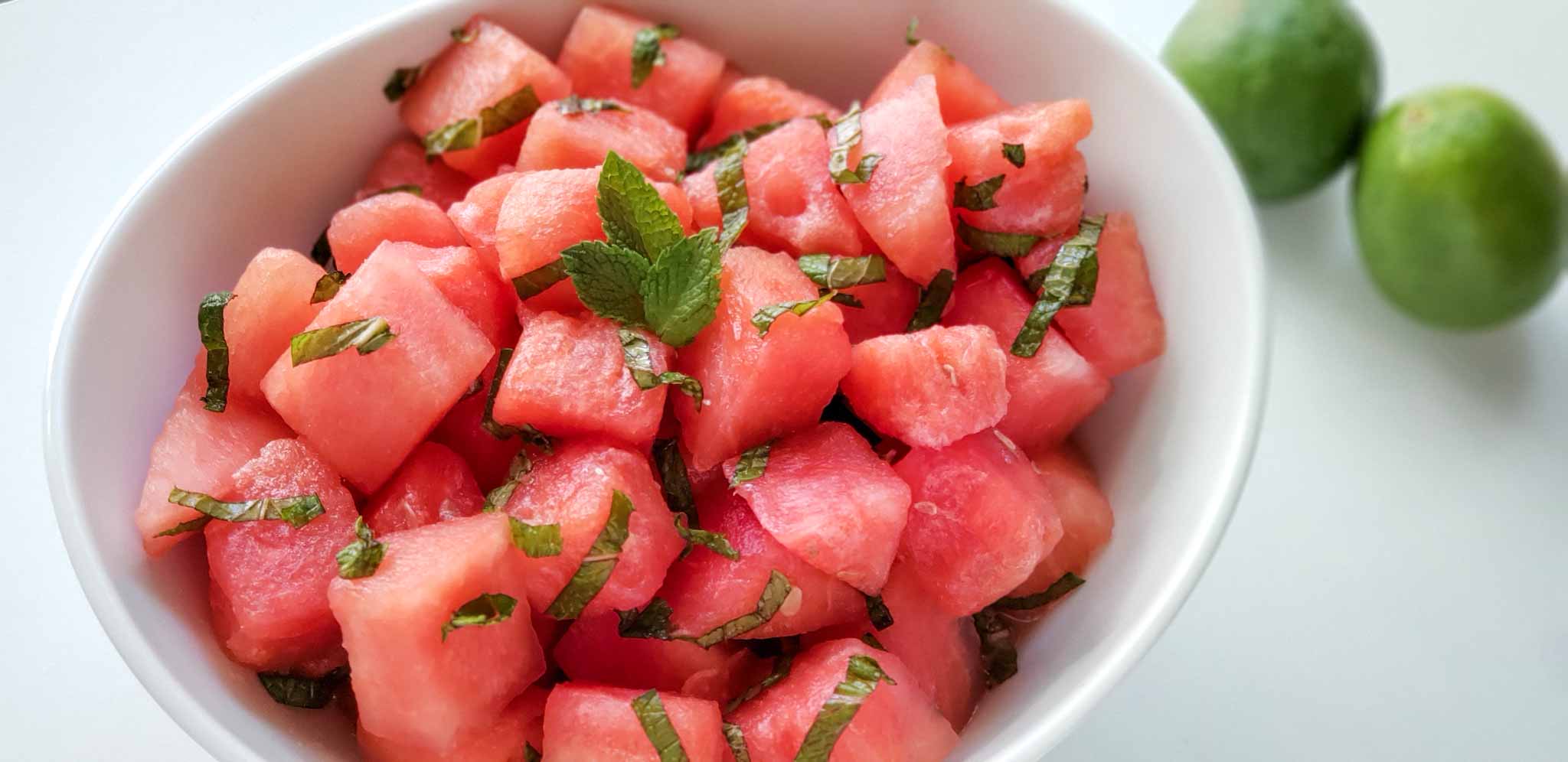 close up of cubed watermelon with strips of mint