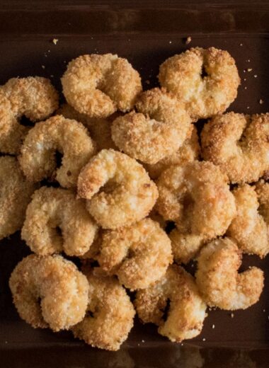 breaded baked shrimp piled onto a brown square plate
