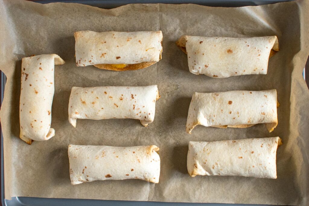 parchment paper with 7 rolled burritos 