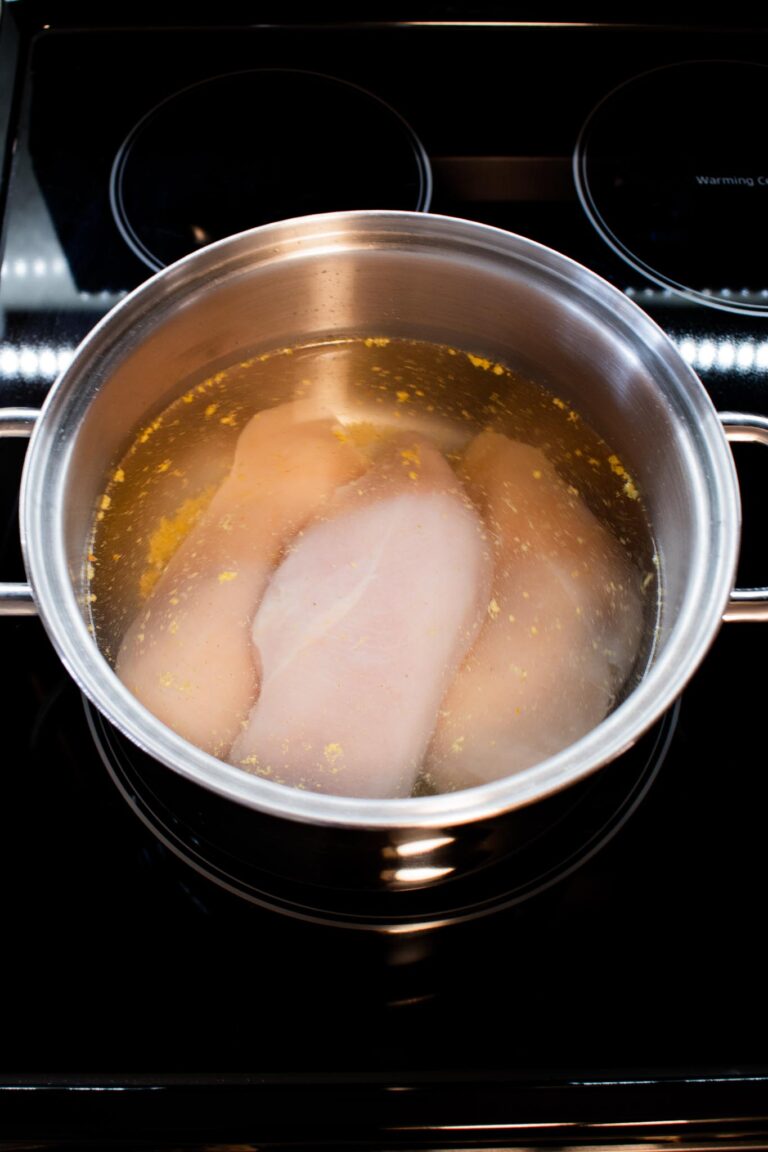 metal pot with chicken breasts and water.
