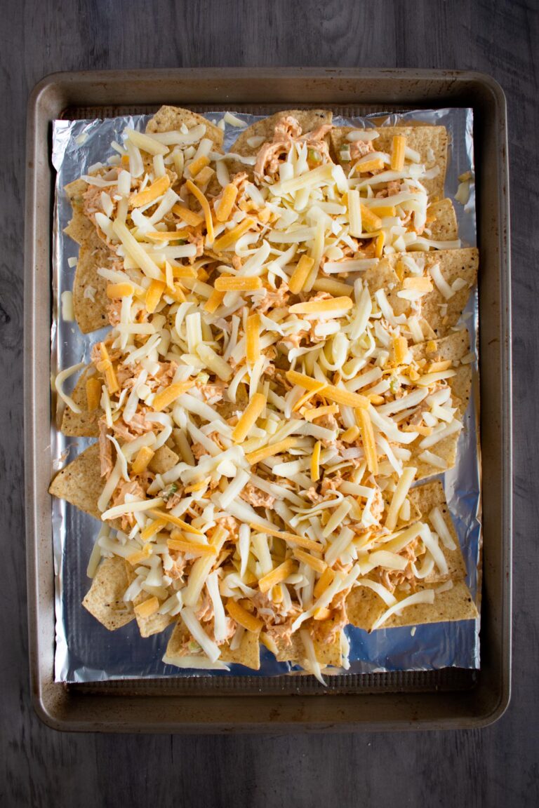 sheet pan lined with  aluminum foil and a layer of chips and shredded buffalo chicken and shredded cheese.
