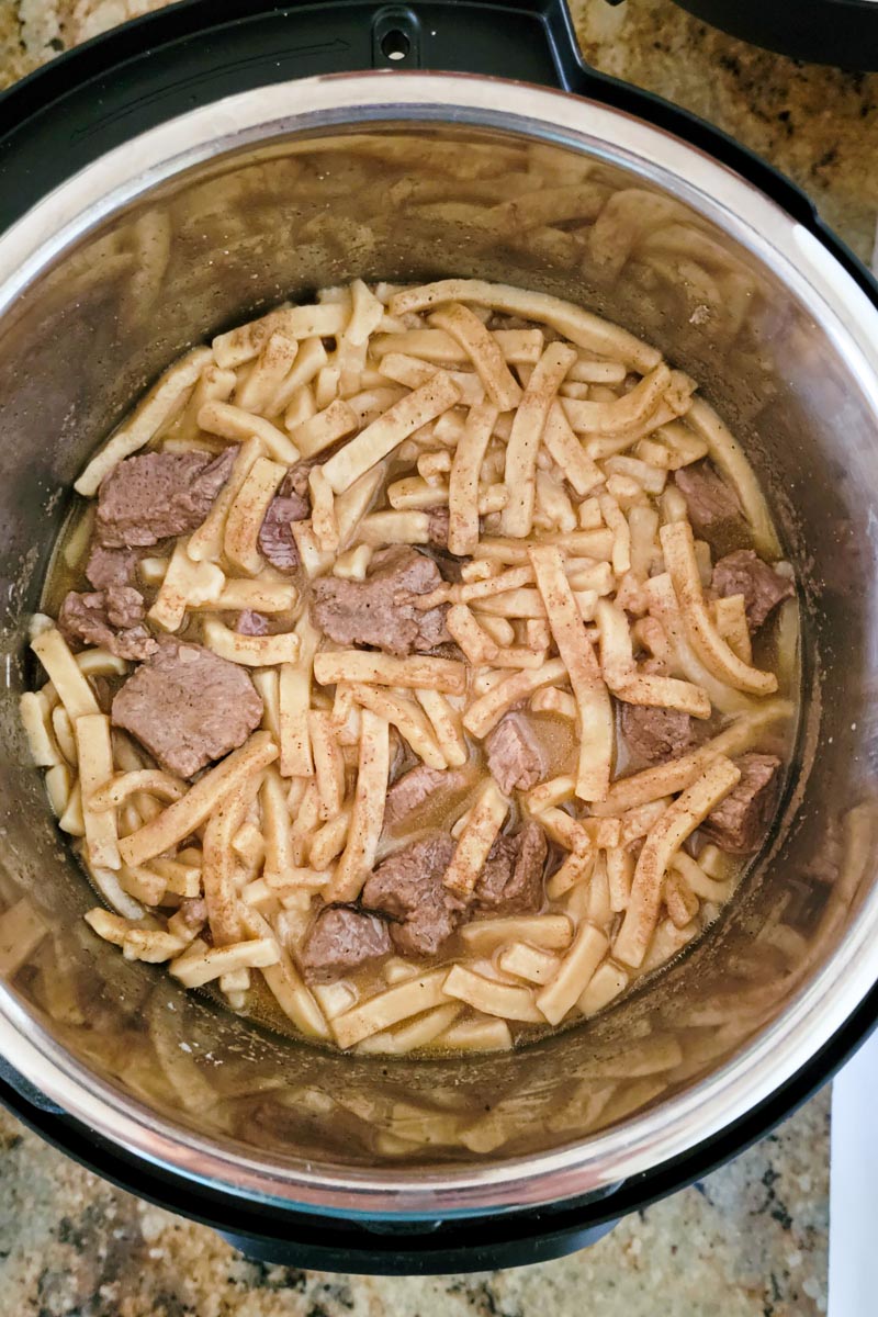 inside of instant pot showing cooked beef and noodles.