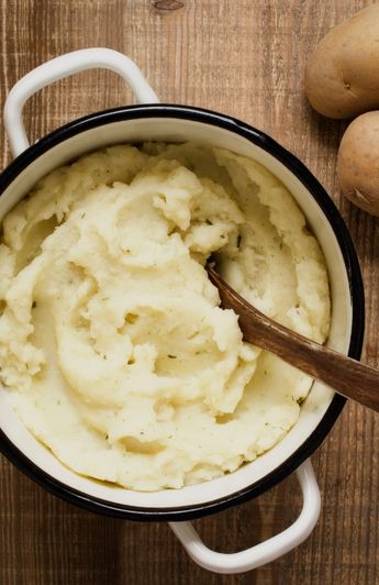 pot of mashed potatoes with a wooden spoon sticking out.